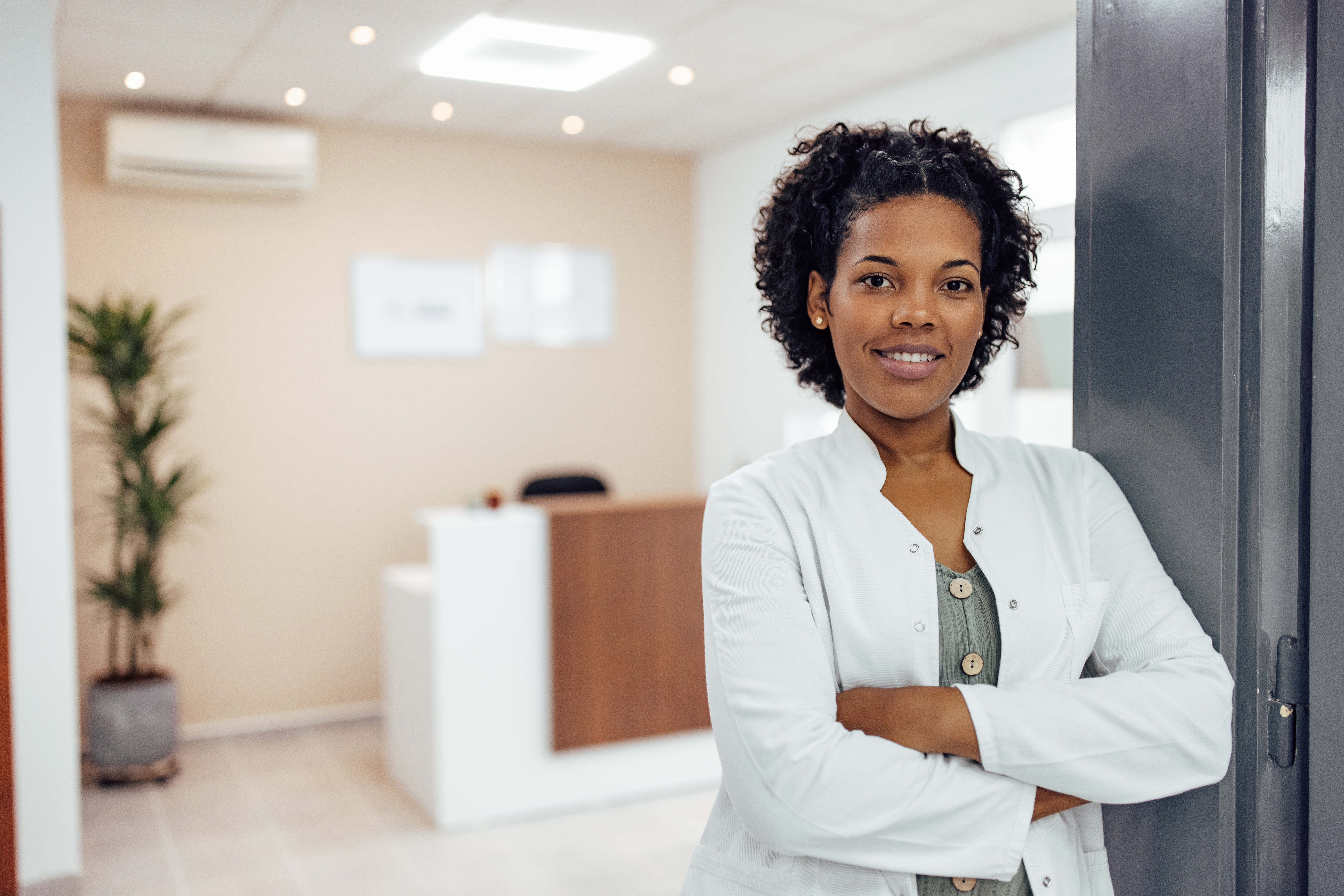 Doctor standing in new clinic space looking thoughtful, symbolizing the emotional journey of launching a medical practice