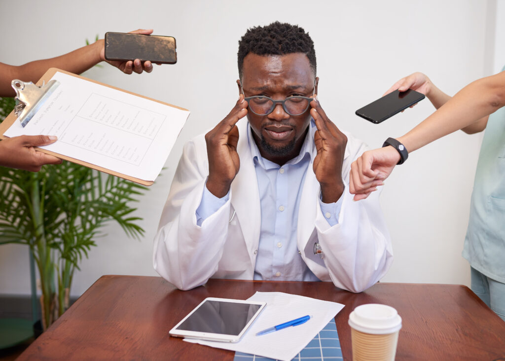 Physician looking contemplative in a clinic office, reflecting on stress and resilience in practice management