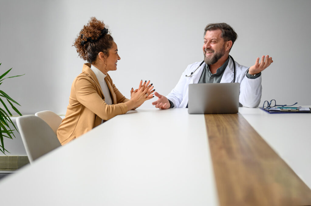 A friendly physician consulting with a patient in a warm, inviting medical office, symbolizing personalized, patient-centered care.