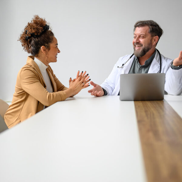 A friendly physician consulting with a patient in a warm, inviting medical office, symbolizing personalized, patient-centered care.